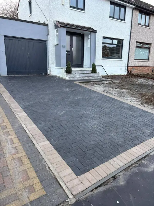 New charcoal block driveway with a light border at the same house